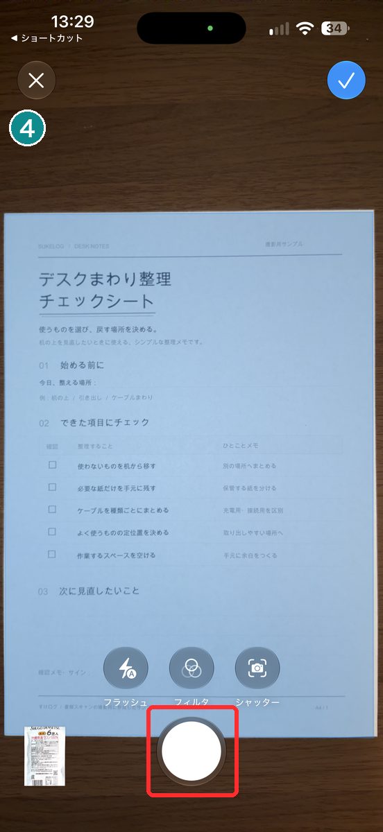 ショートカットから開いた書類をスキャンするカメラの画面。書類が写り、下に丸いシャッターのボタンが見える画面