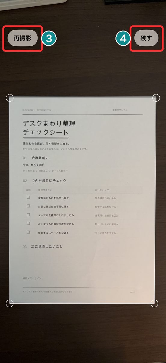 シャッターを押して撮ったあとの画面。書類の四隅に丸印、左上に「再撮影」、右上に「残す」が見える画面